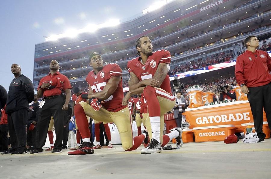 Colin Kaepernick (right) and teammate Eric Reid kneel during the San Francisco 49ers' home opener against the Los Angeles Rams on September 12, 2016.