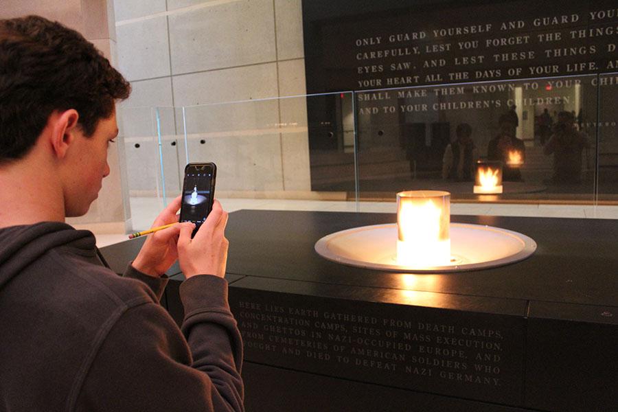 Eighth grader Chase Shapiro takes a photo of the candle that rests upon a crypt of earth taken from Nazi concentration camps in the Holocaust Memorial and Museum.