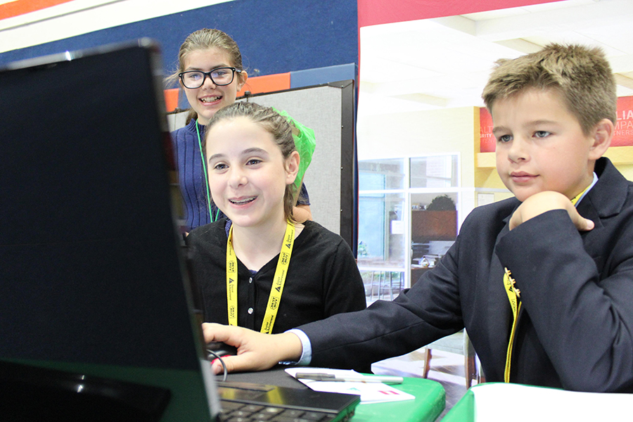 Left to right: Sixth graders Maddie Domnick, Jessica Holland, and Thomas Cornett enjoy working at the bank during their time in BizTown on Friday, February 24.