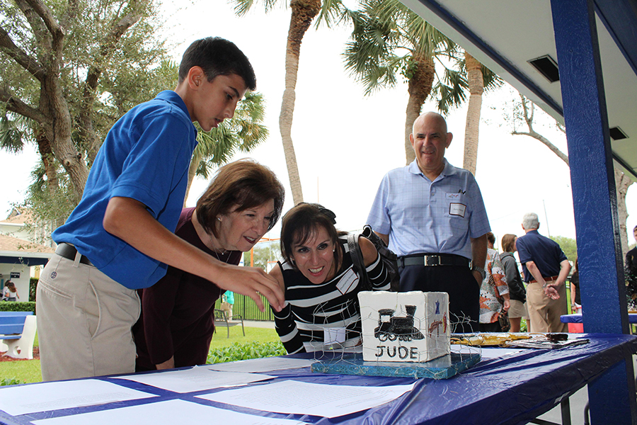 EIghth grader Aidan Neidoff explains his monument project to his grandparents: (left to right) Ms. Rochelle Hollander, Mrs. SHoshanna Neidoff, and Mr. Barry Neidoff.