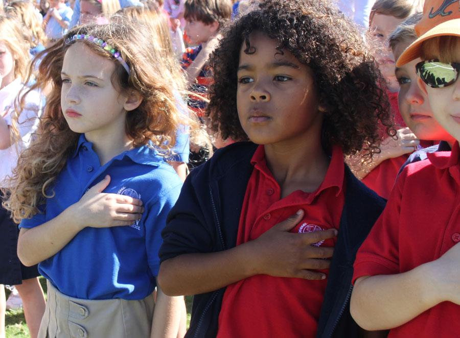 Lower School students place their hands over their hearts while listening to The Star-Spangled Banner.