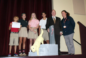 L-R: Eighth graders Blake Larson, Remington Bennett, Morgan Turner, and Matthew Rapaport display the monument they created in honor of Mr. Hingsson and Roselle. Ms. Mack (far right) joins them on stage in the BPAC.