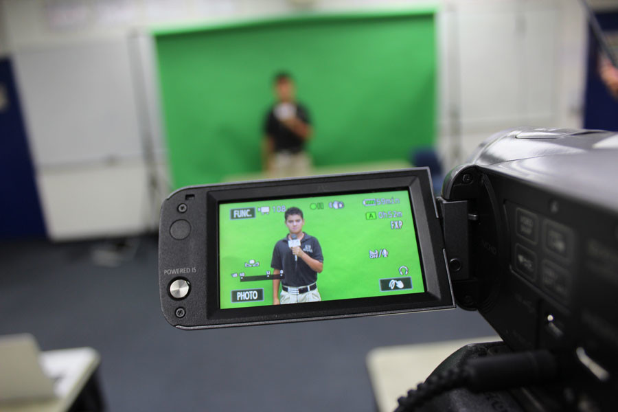 Seventh grader Xander Kline films a portion of his project in front of Mr. Crisafis green screen during the last TV Broadcasting Club meeting on May 8.