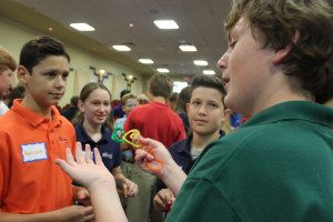 Eighth grader Michael Yancey explains his pipe cleaner configuration to fellow eighth graders (left to right) Alex Wolff, Leslie Berg, and Joey Berg.