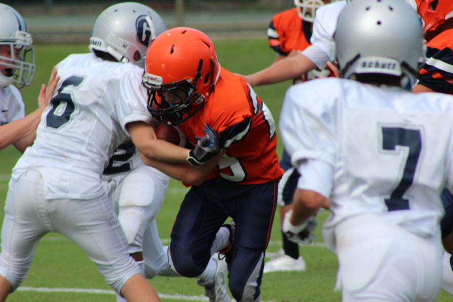 Sixth grader Owen Gelberd fights through the Gulliver defense during the first half of the teams first game on Tuesday, September 8, 2015. Gelberd later scored the Bucs first touchdown of the year.