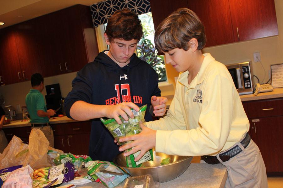 Tommy McCloskey (left) and Christian Baldari  help prepare a salad last year at Quantum House as part of Mr. Bayless and Mrs. Rudners seventh grade advisories. The students prepared a meal to feed families whose children were being treated at  local hospitals.