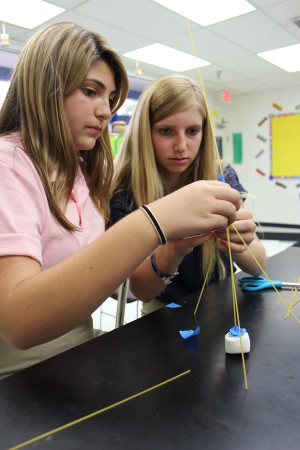 Eighth graders Sophie Rabiei (left) and Regan Kretz concentrate on making their tower of spaghetti as tall as possible.