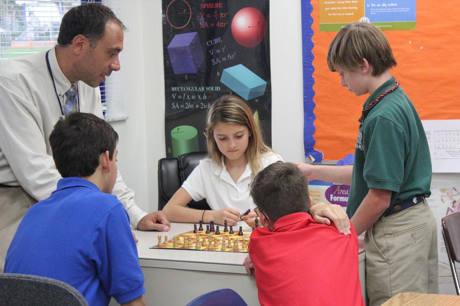 Mr. DiGiovanni oversees seventh grader Bianca Lanni (center) set up the board in his Chess Club. Lanni has never played chess before and is joined by club members (left to right) Joey Palomba, Anthony Cavallo, and Owen Gelberd. 