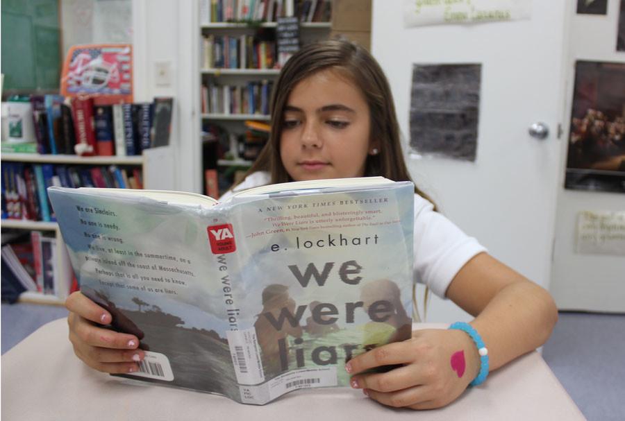 During RAAP, seventh grader Sydney Haselkorn reads "We Were Liars" by E. Lockhart, who happened to visit and speak with the middle school students last year.