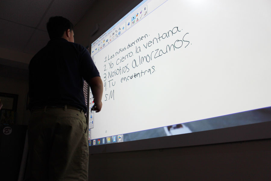 Eighth grader Billy Moscatello writes a sentence in Spanish using the new interactive surface via the Epson projector in Mr. Charles Maddoxs classroom. 
