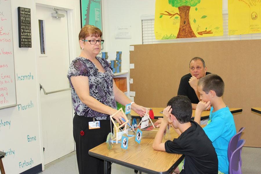 Middle School Department Chair Ms. Gabriele St. Martin shows the fifth graders one of the balloon cars her students made in class as she tells them about the science program.
