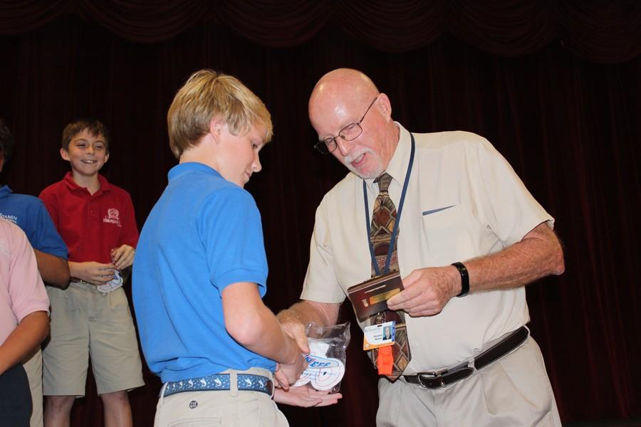 Mr. Mullnix presents an sixth grader Jack Savery with the Most Improved Player Award for football.