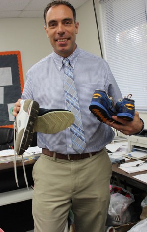 Mr. DiGiovanni holds up a couple of pairs of sneakers that were donated.