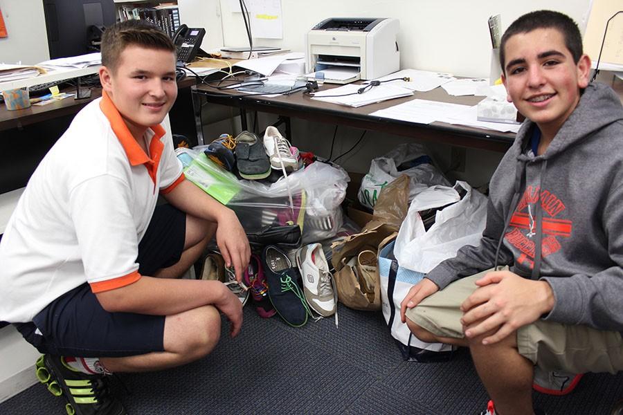 Seventh graders Hudson Hale (left) and Alex Michelon pose next to the bags of shoes in Mr. DiGiovannis room. Hale and Michelon both made donations to the Soles4Souls initiative.