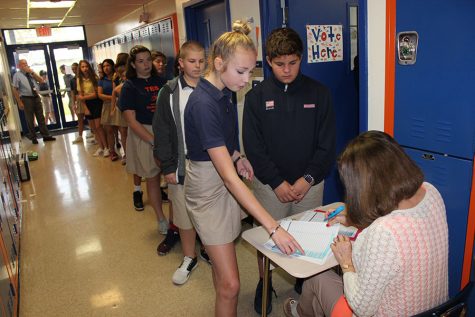 Eighth grader Ebaa Kihlberg helps substitute teacher Ms. Arencibia find her name before she heads into room 50 to vote.