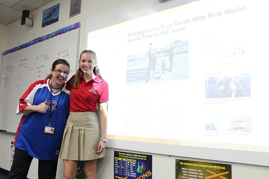 Mrs. Hansen and eighth grader Kate Lower, both Chicago natives, pose next to the interactive white board which touts the fact that the Cubs championship drought has ended.