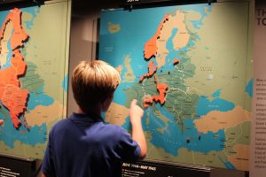 Eighth grader Carter Stewart, looking at a map in the United States Holocaust Memorial Museum, traces the Allies' path when they invaded Nazi Germany during WWII.