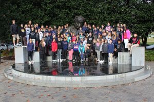 The eighth-grade class poses with a statue of Albert Einstein. 