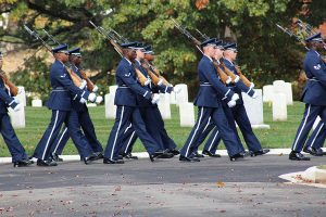 Navy airmen march through Arlington National Cemetery during a funeral procession.