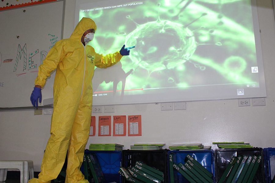 Seventh grader Jack Horgen dons a hazmat suit in order to make his presentation on SARS.