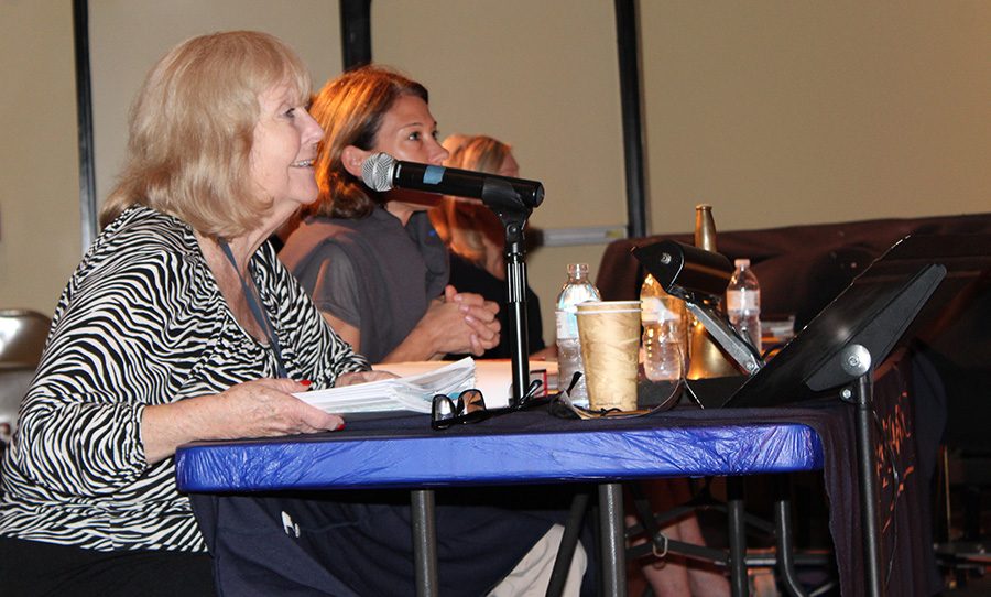 ENglish Department Chair Mrs. Kathleen Devine provides a student with a word during the competition.