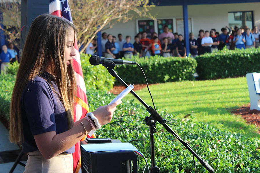 Eighth grader Sydney Steinger reads a portion of President Trumps speech to the middle school students  in the quad.