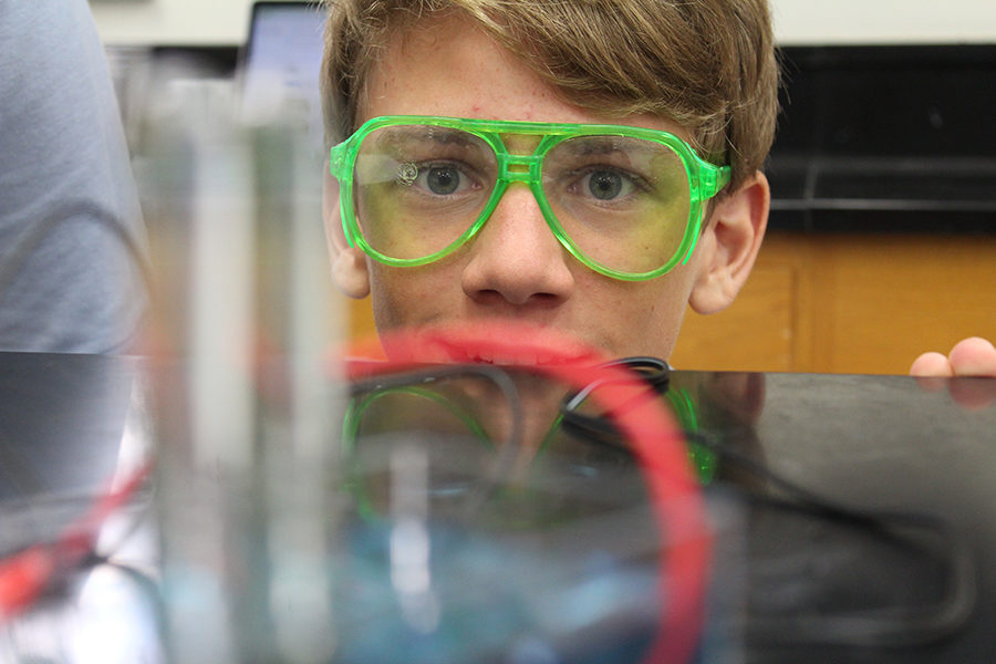 Eighth grader Cole McIlvaine watches as the water is turned into separate gases within his groups test tubes during his SEAT class.