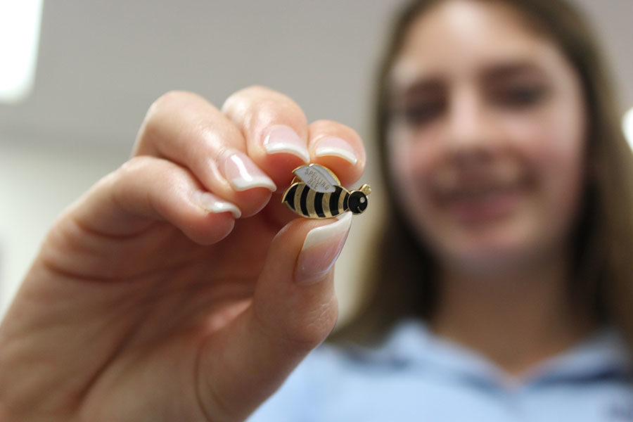 Eighth grader Caroline Yancey holds up her bee pin after winning the contest in Mrs. Devines E period.
