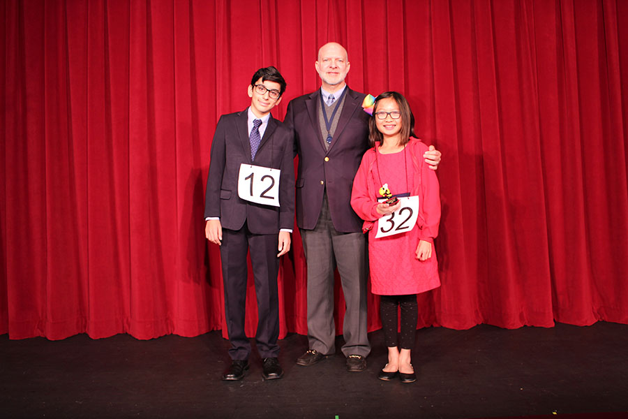 Sixth-grade spelling bee winner Claire Dinh (right) poses with seventh grader and runner-up Kiran Spencer and Head of Middle School Mr. Charles Hagy after the competition in the Barker Performing Arts Center.