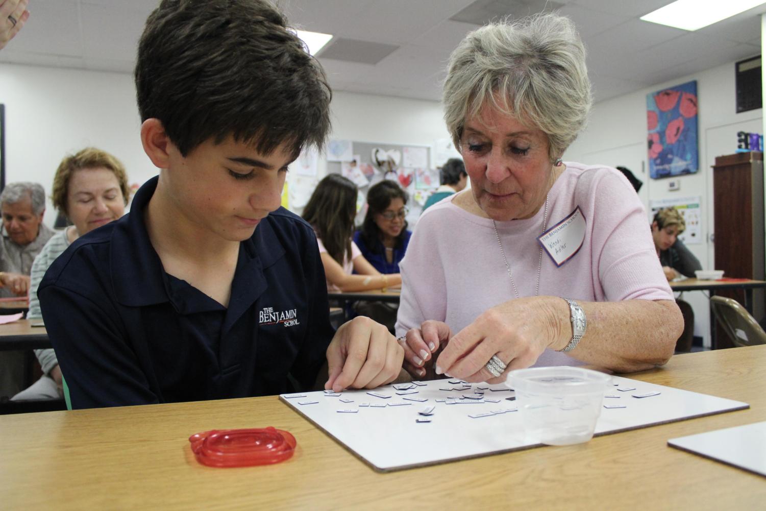 Eighth grader Jake Zur and his grandmother, Wendi Adler, create a poem with magnetic words in Mrs. Devine's room on Grandest Friends' Day.