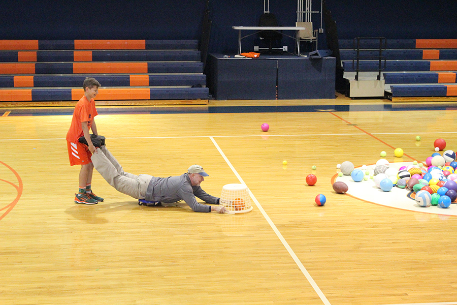 Eighth grader Matthew Postman and Head of Middle School Mr. Charles Hagy demonstrate how to play Hungry Hungry Hippos for the rest of the students.