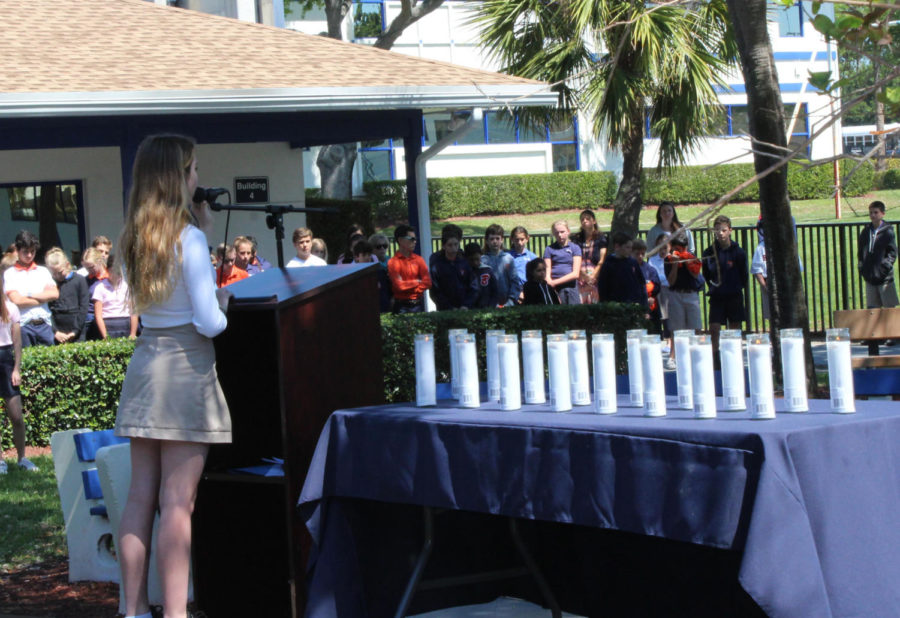 Amidst the 17 lit candles, eighth grader Catherine Schenk sings Somewhere Over the Rainbow surrounded by middle school students in the quad on March 14.
