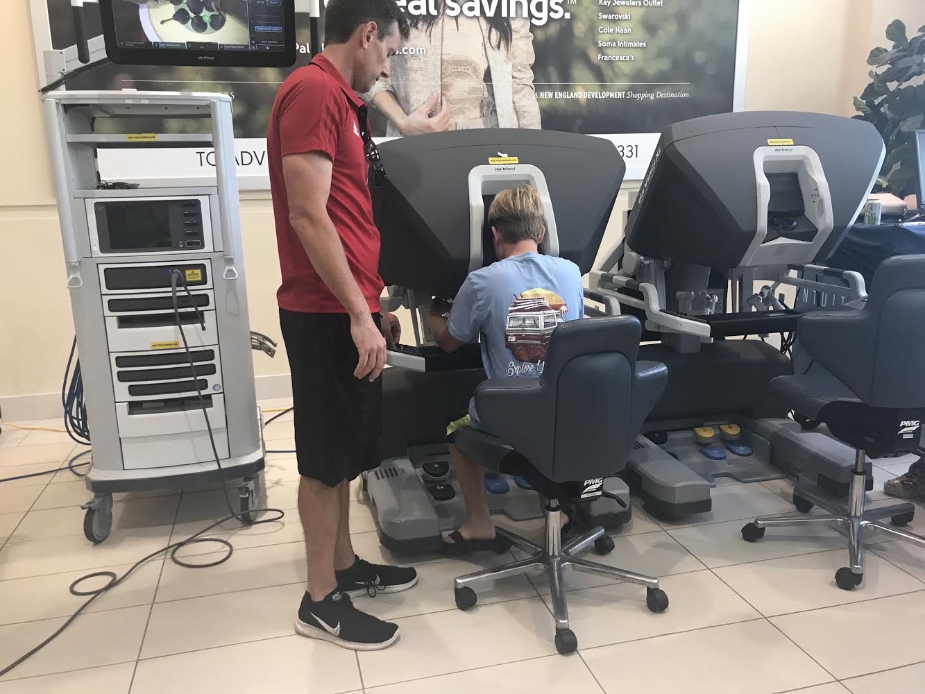 With the help of a Good Samaritan Medical Center staff member, sixth grader Colby Mack (seated) tries his hand at controlling the da Vinci Xi.