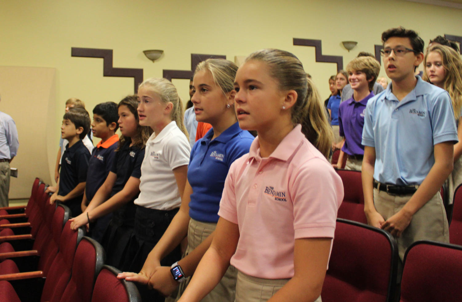 Middle School students stand and sing the
