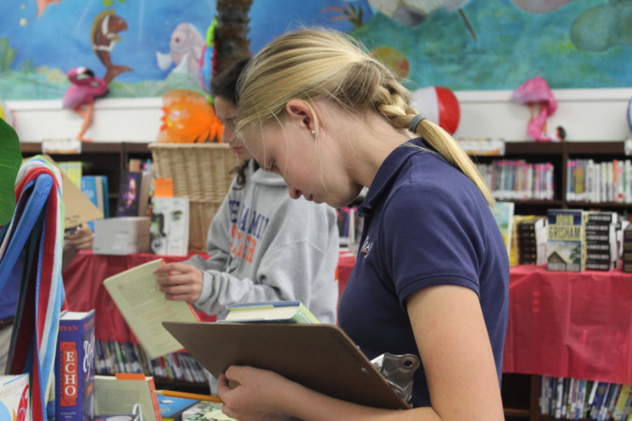 Seventh grader Addie Vining looks for her summer reading books in the library/media center.