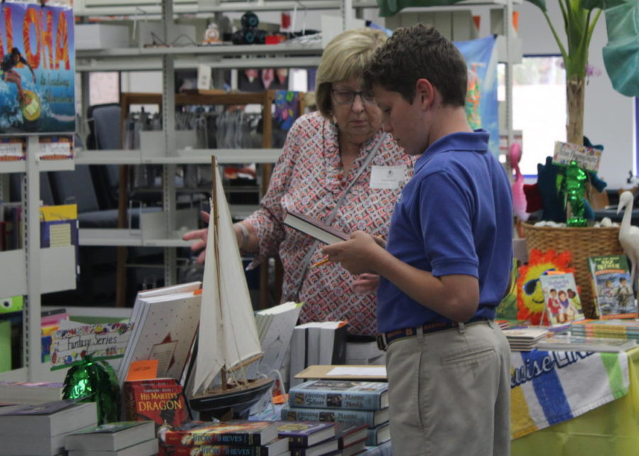 Seventh-grade+student+Arthur+Wolff+checks+out+a+book+at+The+Benjamin+School+Book+Fair.