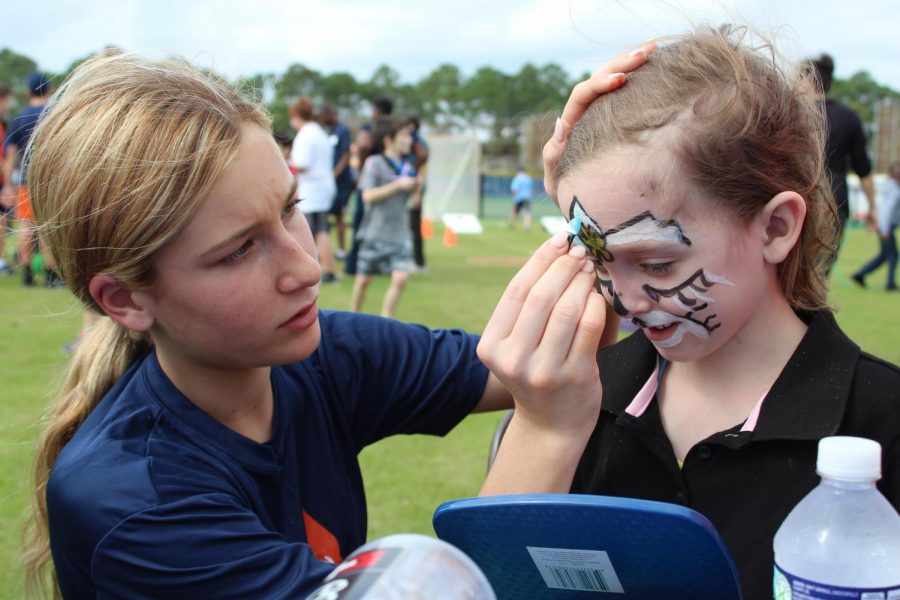 Sofia Abbonizio paints a students face during the Friendship Games.