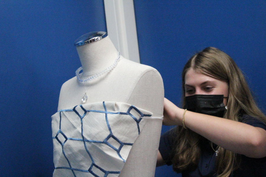 Eighth grader Abbey Trousdale puts the finishing touches on the outfit she designed in Ms. McAllisters visual art class. 