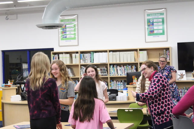 Mrs. Cathy Hansen bonds with some of the fifth-grade students while getting to know them in the newly renovated Library/Media Center. 