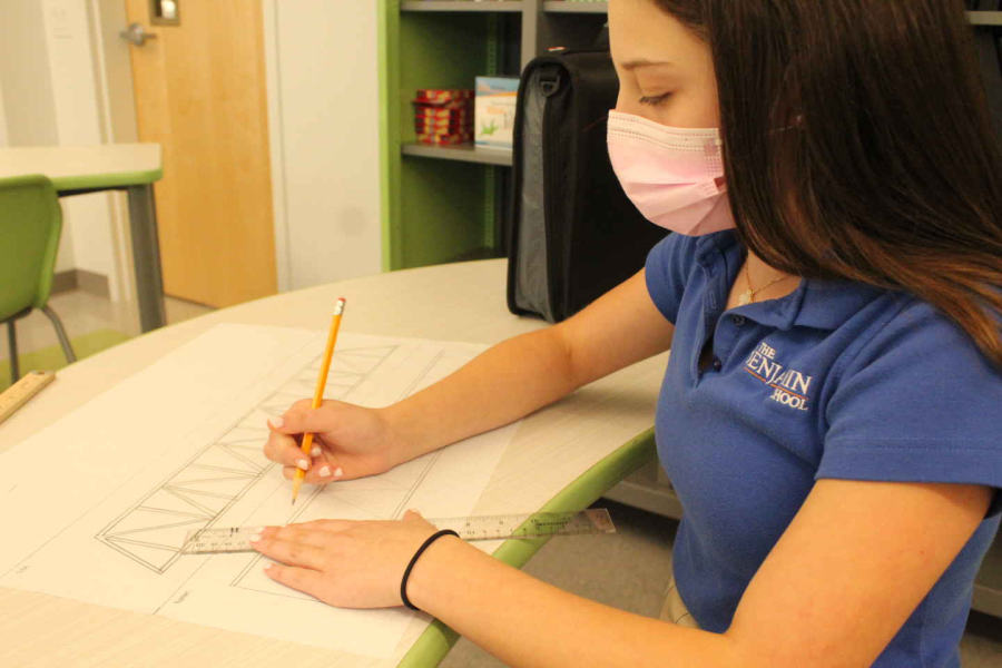 Eighth grader Lila Cooper sketches out her bridge in STEM class.