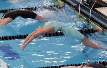 Feagin Kaminski (in the turquoise) swims a backstroke in a competition. 