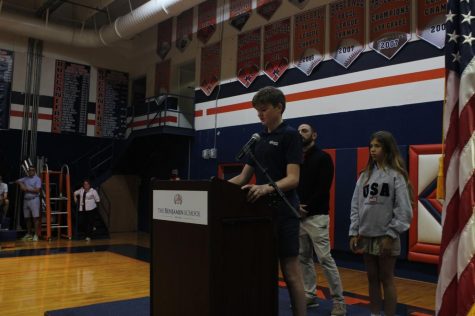 Student Council President Thomas Harris reads the names of veterans in middle school student’s families.