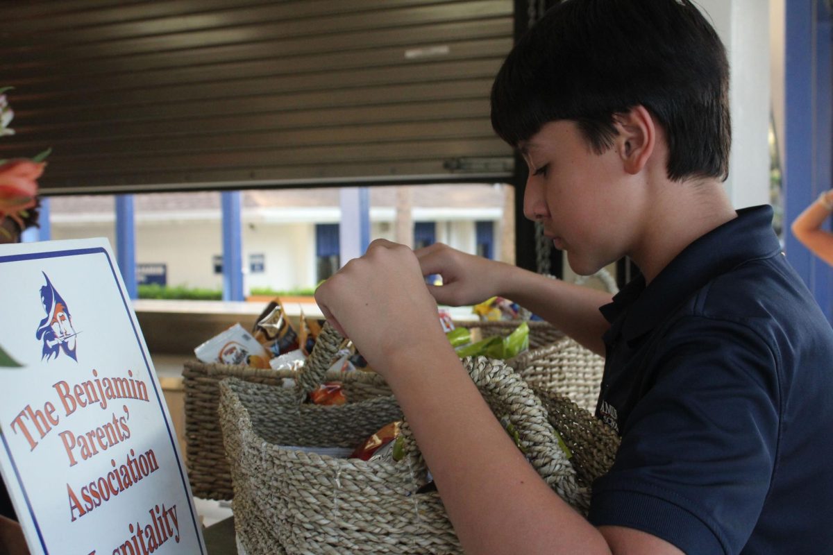 8th grader Michael Alvarez organizes organizes snacks for parents to enjoy